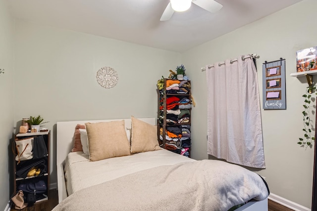 bedroom with baseboards, ceiling fan, and dark wood-type flooring