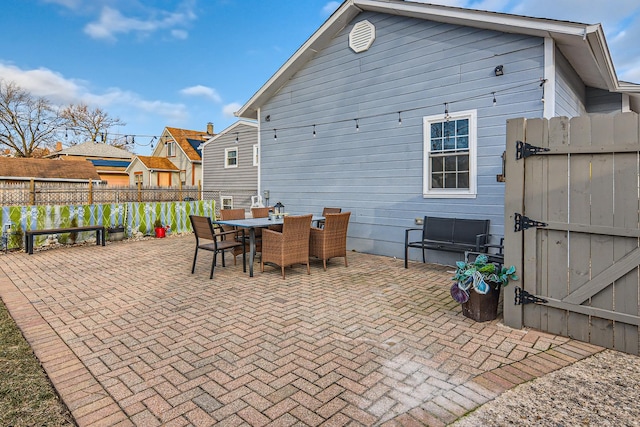 rear view of house featuring fence, outdoor dining space, and a patio area