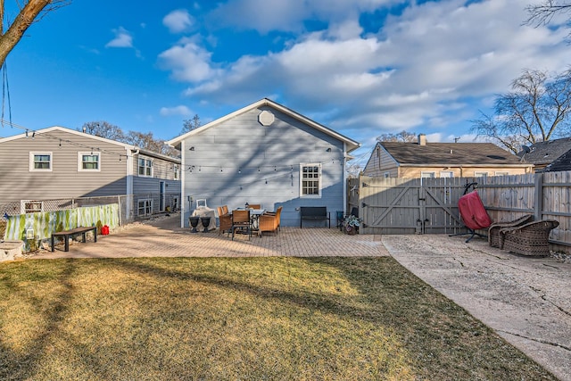 back of house with fence, a gate, a patio, and a yard