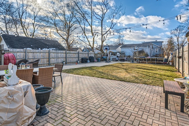 view of patio with a fenced backyard, a trampoline, outdoor dining area, and a residential view