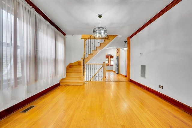 3016 N Major Ave, Chicago, IL 60634 - unfurnished living room featuring an inviting chandelier, visible vents, baseboards, and arched walkways