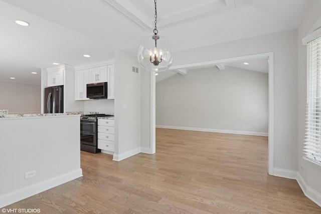 kitchen featuring stainless steel range with gas cooktop, freestanding refrigerator, white cabinetry, light wood-type flooring, and plenty of natural light