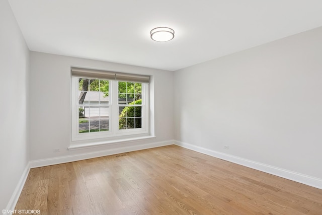 unfurnished room featuring baseboards and light wood-style flooring
