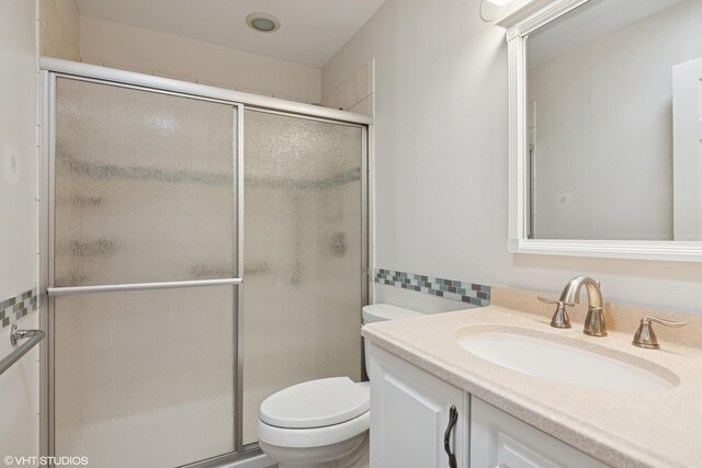 full bathroom featuring toilet, a stall shower, and vanity