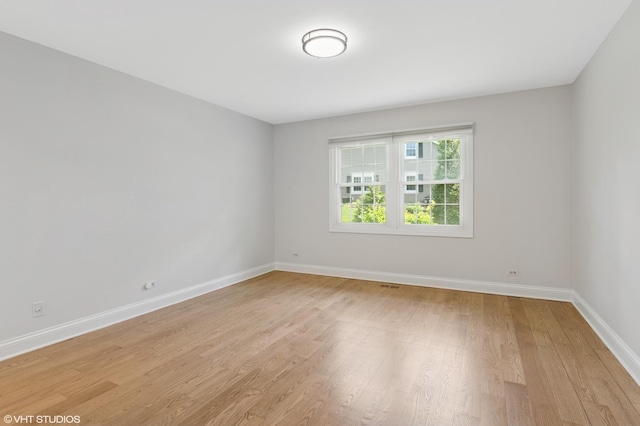 empty room featuring baseboards and light wood-type flooring