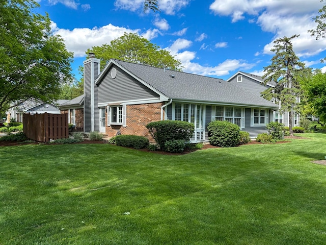 rear view of property with a chimney, a shingled roof, and brick siding