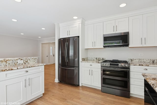 kitchen with appliances with stainless steel finishes, crown molding, white cabinets, light wood finished floors, and light stone counters