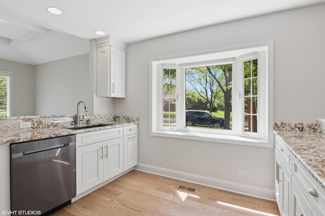 kitchen with stainless steel dishwasher, a sink, light wood-style flooring, baseboards, and white cabinetry