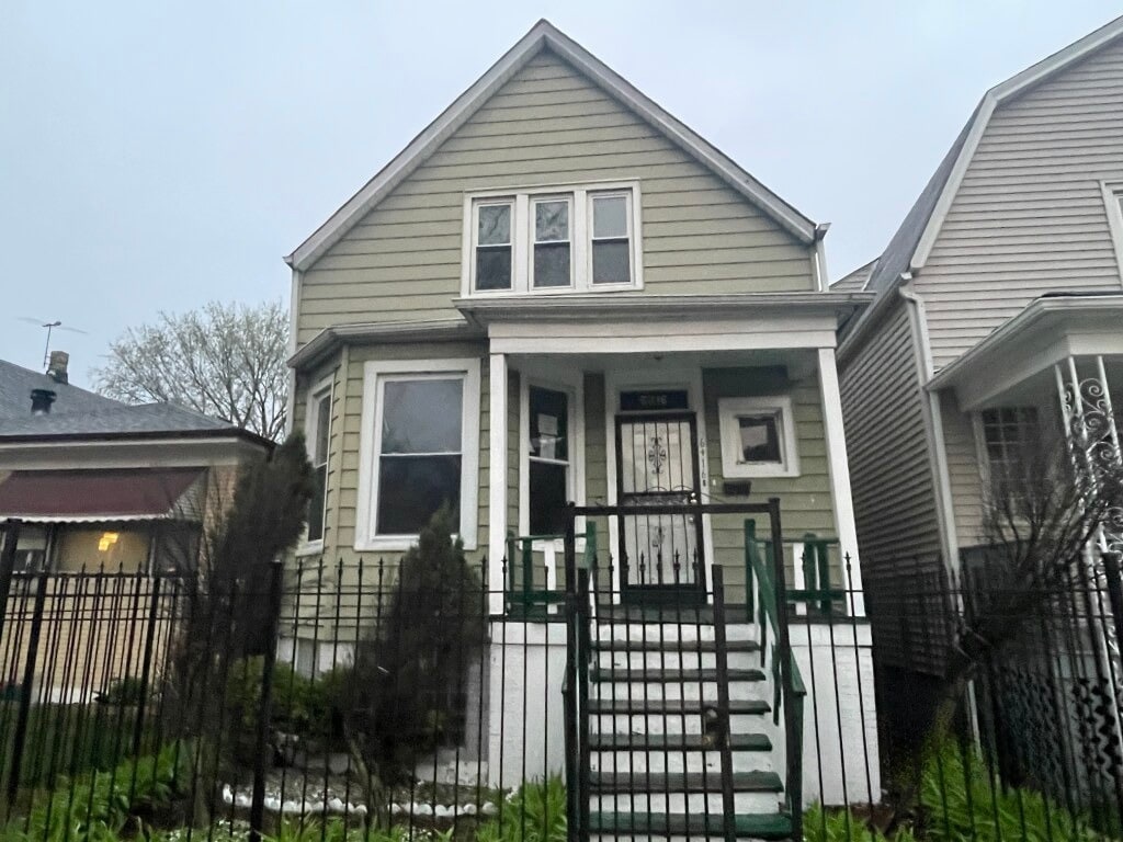 shotgun-style home with covered porch and fence private yard