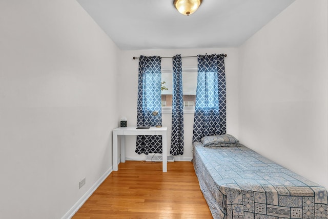 bedroom featuring baseboards and wood finished floors