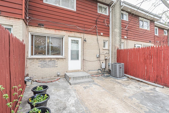 back of property with brick siding, central AC, fence, and entry steps