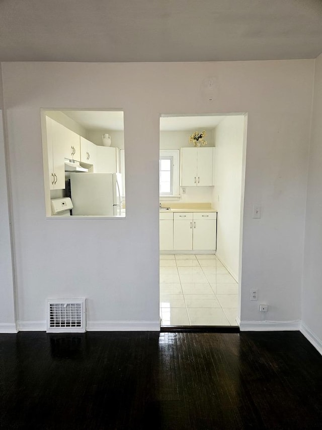 interior space featuring baseboards, visible vents, and light wood finished floors