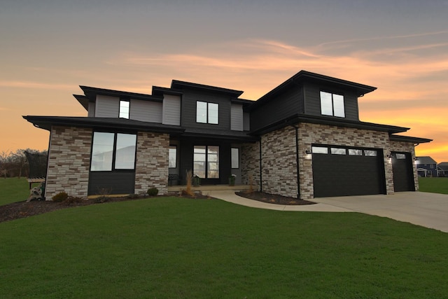 view of front of home featuring a lawn, driveway, stone siding, and a garage