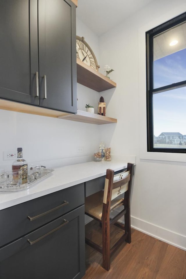 interior space featuring baseboards and dark wood-style floors