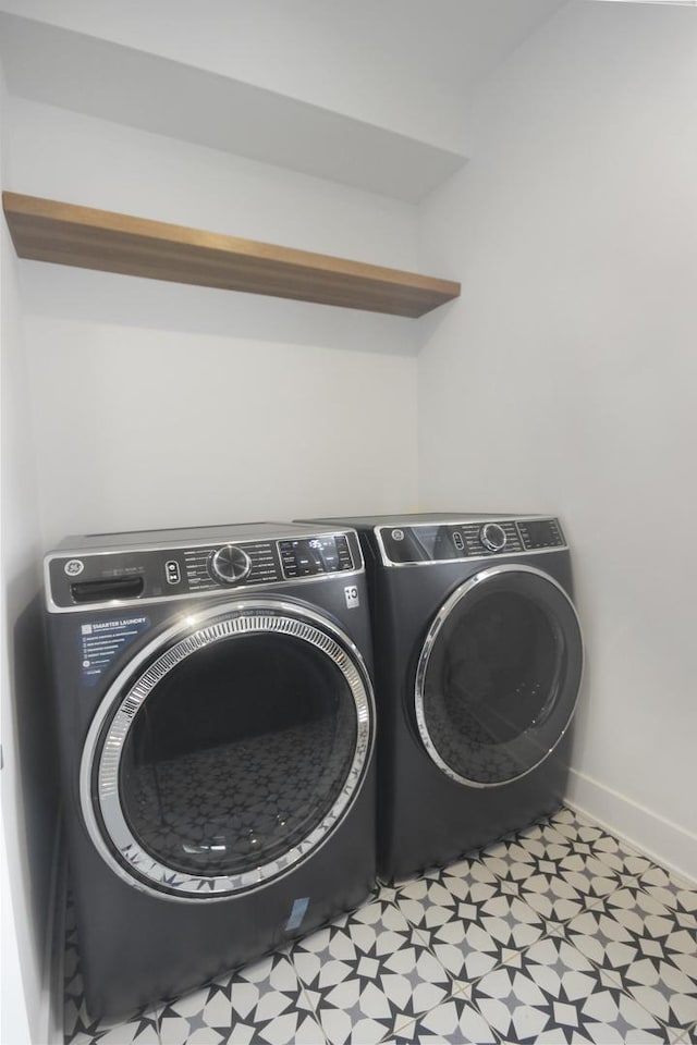 laundry room featuring separate washer and dryer, laundry area, baseboards, and light floors