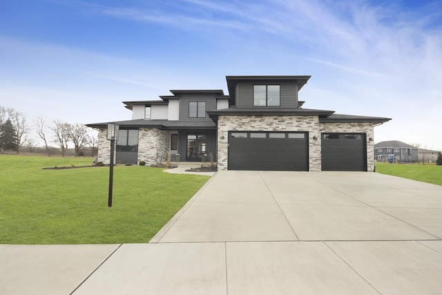 prairie-style home featuring a garage, stone siding, concrete driveway, and a front yard