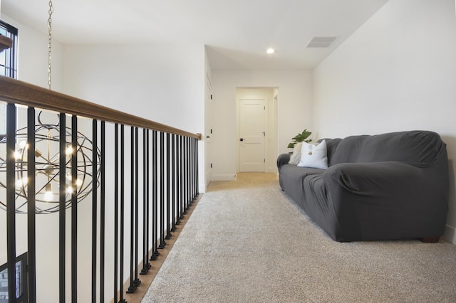 hallway featuring visible vents, light carpet, baseboards, recessed lighting, and a chandelier