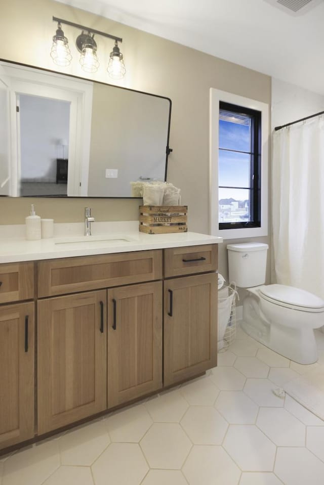 full bath with vanity, toilet, and visible vents