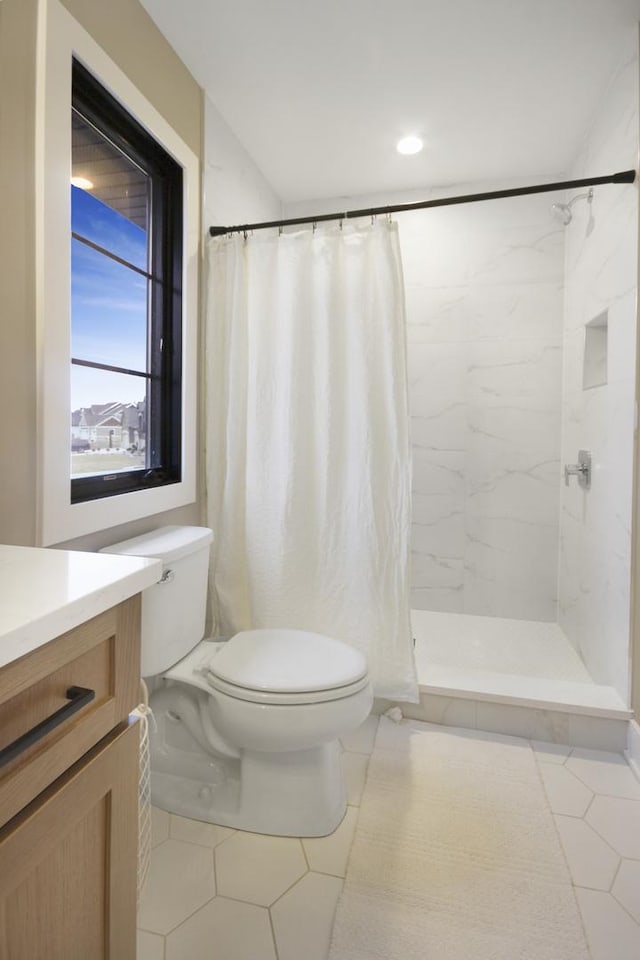 bathroom featuring tile patterned flooring, curtained shower, toilet, and vanity