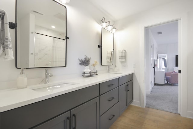 bathroom featuring visible vents, a sink, and wood finished floors