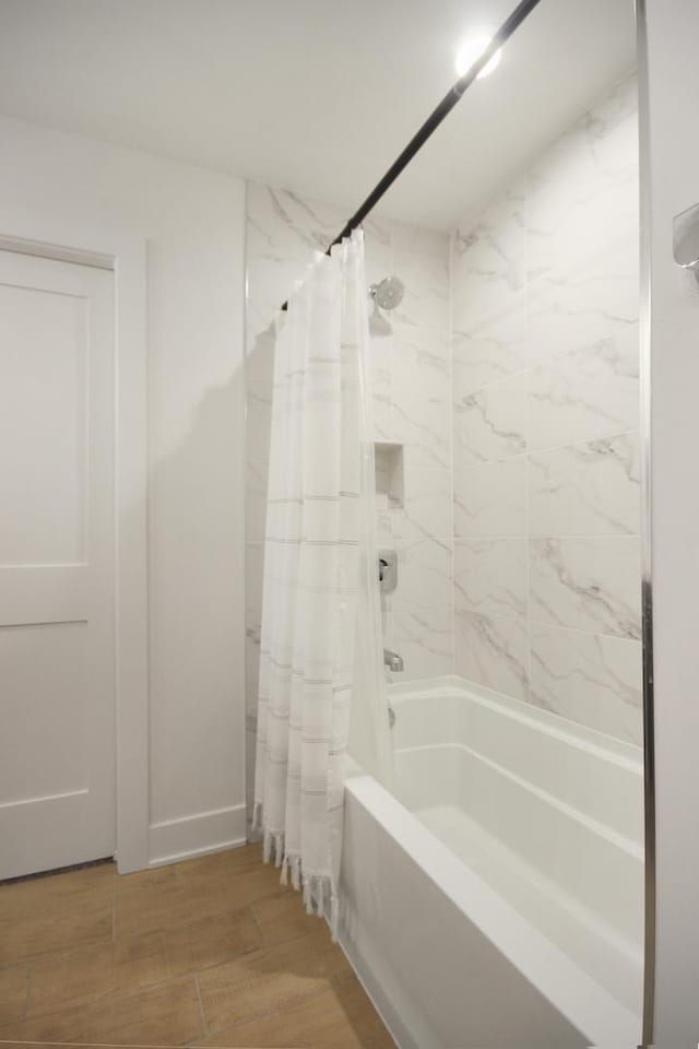 bathroom with wood finished floors and shower / bath combination with curtain