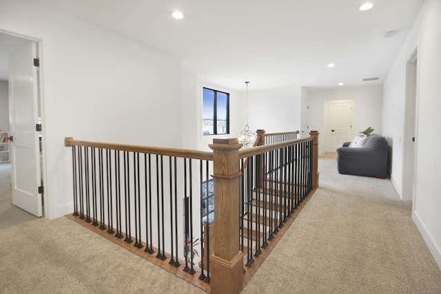 corridor featuring recessed lighting, an upstairs landing, and carpet