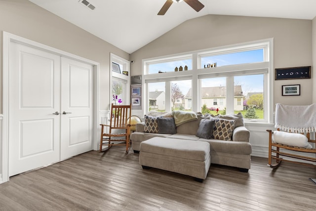 living area with visible vents, wood finished floors, ceiling fan, plenty of natural light, and vaulted ceiling