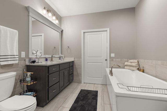 bathroom featuring double vanity, toilet, tile walls, and a bath