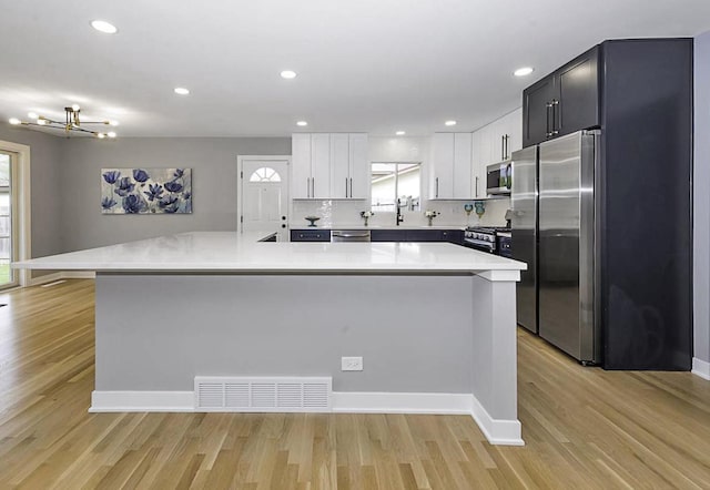 kitchen with visible vents, light countertops, light wood-style flooring, and appliances with stainless steel finishes