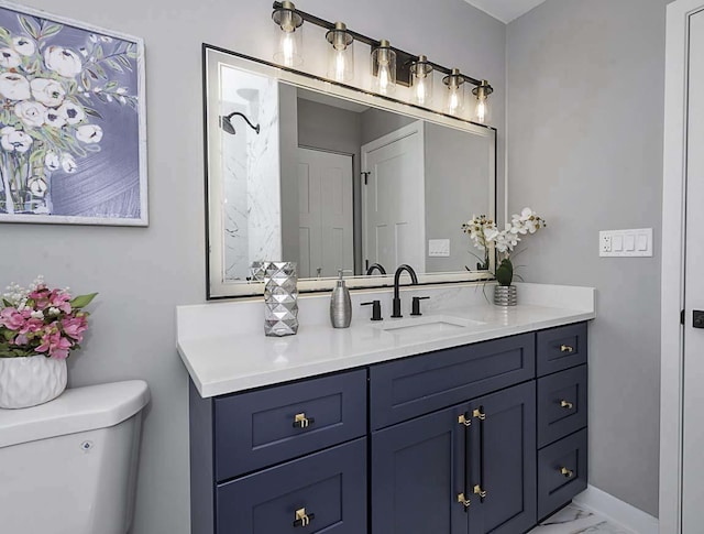 bathroom featuring toilet, marble finish floor, and vanity