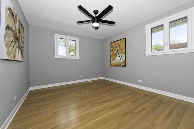 unfurnished room with a ceiling fan, baseboards, and wood finished floors