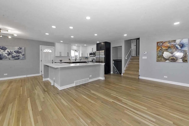 kitchen featuring visible vents, light countertops, light wood-style floors, stainless steel appliances, and recessed lighting