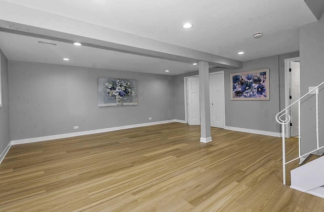 finished below grade area featuring baseboards, recessed lighting, light wood finished floors, and stairway