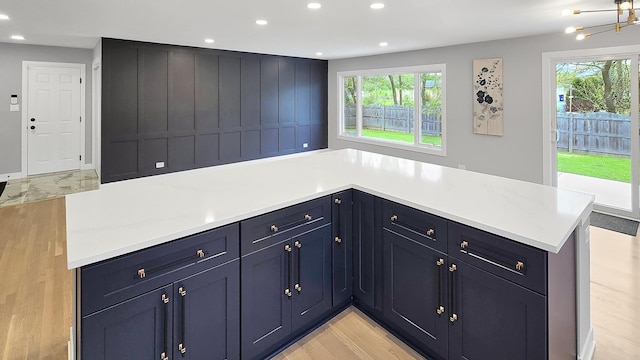 kitchen with a healthy amount of sunlight, recessed lighting, light wood-style flooring, and a chandelier