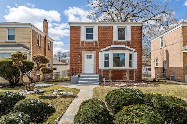 view of front facade featuring brick siding, fence, and a chimney