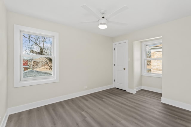 empty room featuring baseboards, ceiling fan, and wood finished floors