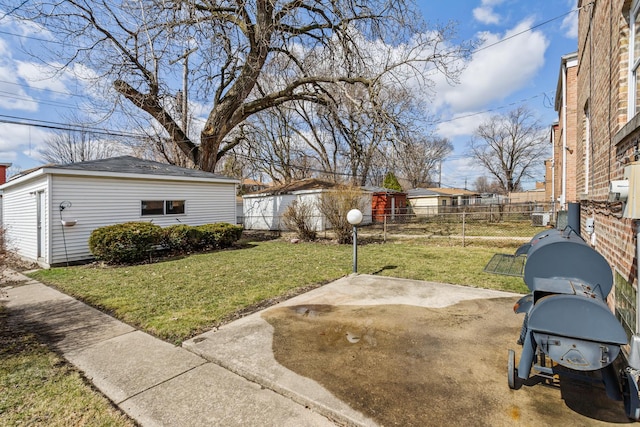 view of yard with fence, an outdoor structure, and a patio area
