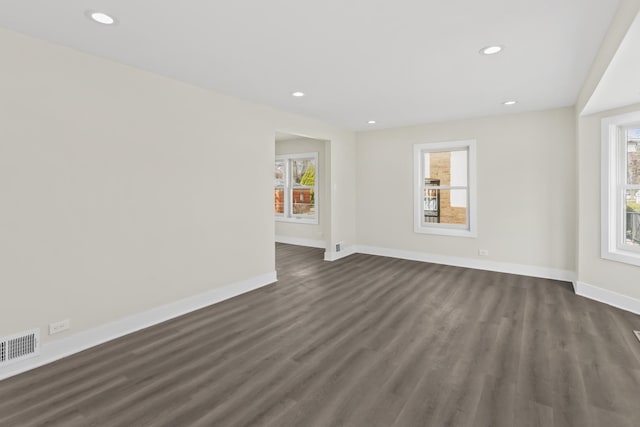 unfurnished living room with a healthy amount of sunlight, baseboards, and visible vents