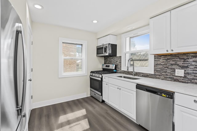 kitchen with a sink, plenty of natural light, stainless steel appliances, and tasteful backsplash
