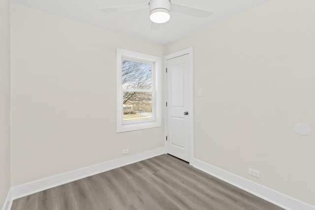 spare room featuring baseboards, ceiling fan, and wood finished floors