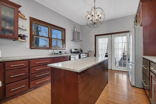 401 7th St, Mazon, IL 60444 - kitchen with stainless steel gas range, a sink, freestanding refrigerator, wall chimney range hood, and light wood-style floors