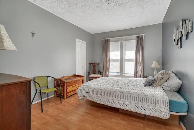 401 7th St, Mazon, IL 60444 - bedroom with light wood-style floors, a textured ceiling, baseboards, and a closet