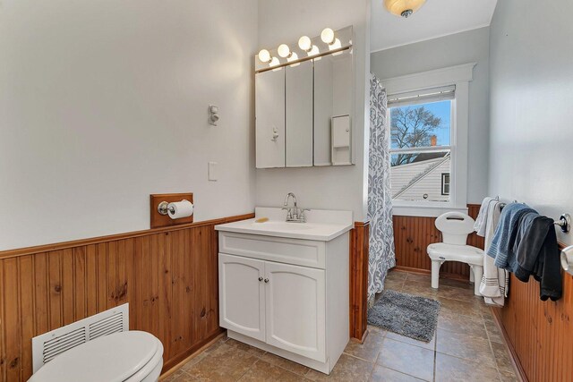 401 7th St, Mazon, IL 60444 - bathroom featuring a wainscoted wall, toilet, vanity, and wood walls