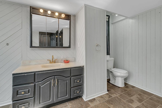 401 7th St, Mazon, IL 60444 - bathroom with wood walls, toilet, vanity, and baseboards