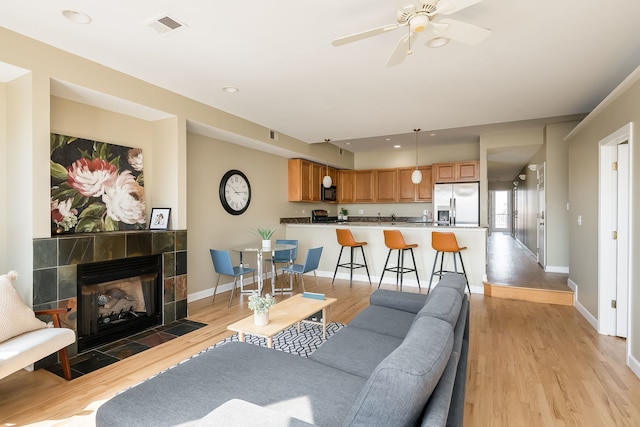 612 S Western Ave Unit 3, Chicago, IL 60612 - living area featuring baseboards, light wood-style flooring, visible vents, and a tile fireplace