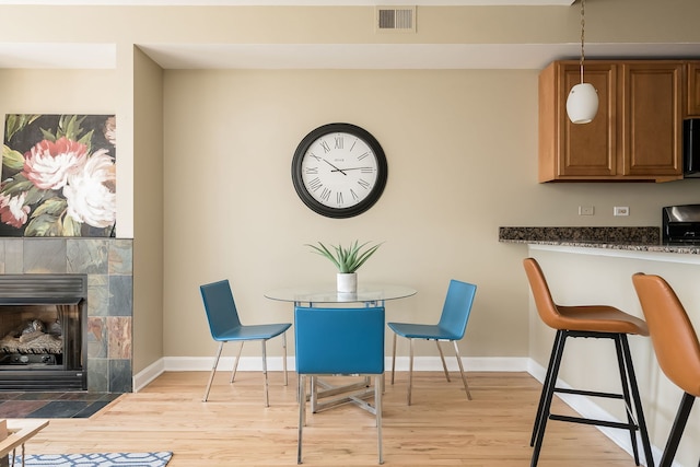 612 S Western Ave Unit 3, Chicago, IL 60612 - dining space with visible vents, light wood-style flooring, baseboards, and a fireplace