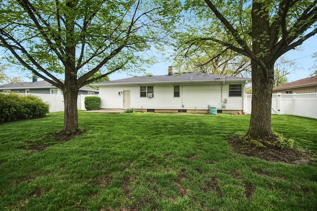 back of property featuring a yard, a chimney, and fence