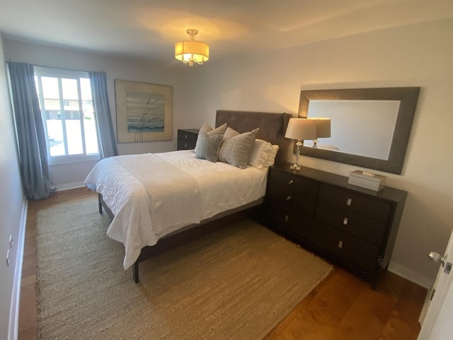 bedroom with wood finished floors and baseboards