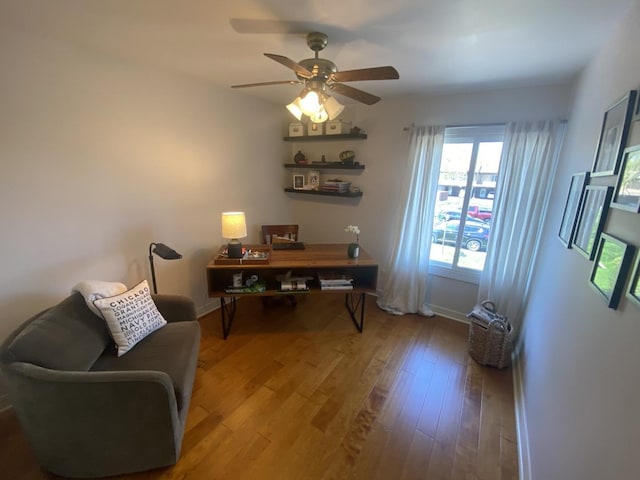home office with wood finished floors, a ceiling fan, and baseboards