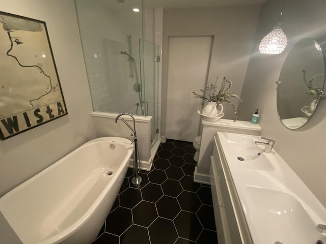full bath featuring tile patterned flooring, a freestanding bath, a shower stall, toilet, and double vanity
